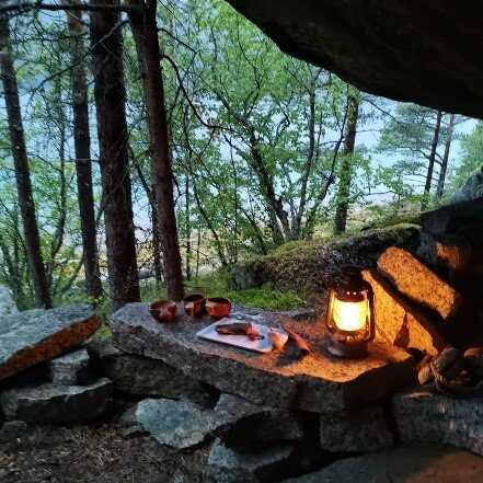 Wooden cups and lantern on a stone slope outdoors in nature.