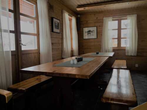 Interior with wooden benches and tables Mollisjok mountain lodge.