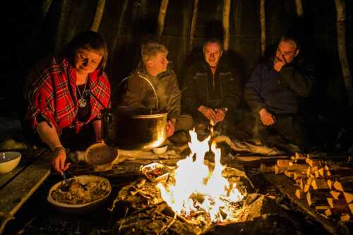 People around a campfire inside the lavvo.