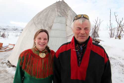 Sami hosts in front of the goahti.