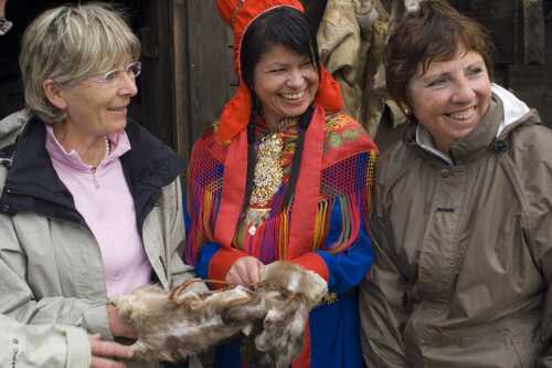 Dame i samisk drakt sammen med gjester