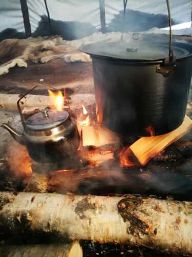 Kjele som koker over bål i samisk lavvo i Karasjok.